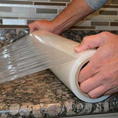 Protective Film is being placed on top of a granite surface.